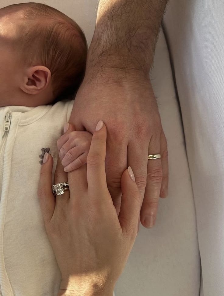 A parent gently holding a newborn